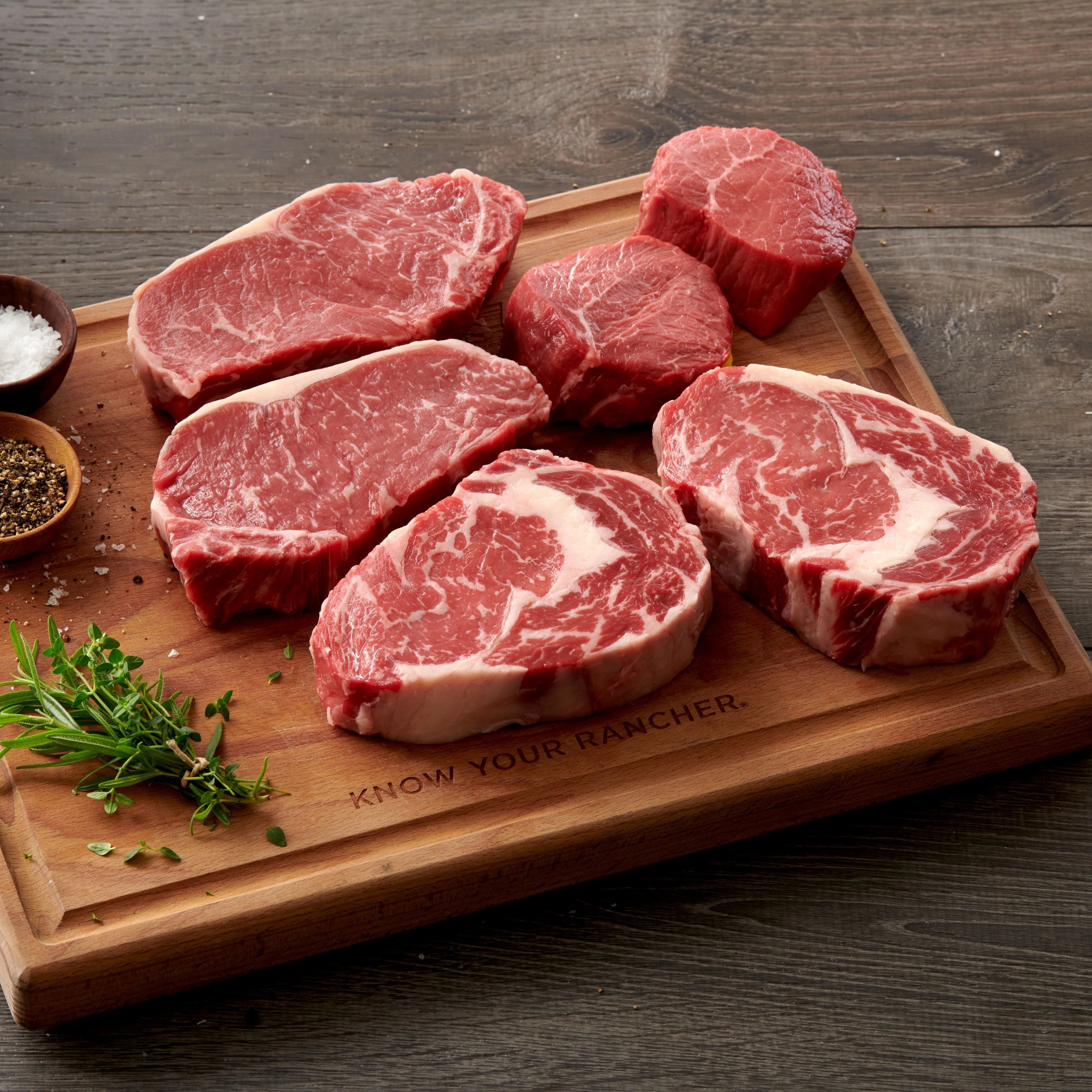 multiple USDA Choice Steak cuts on cutting board with seasoning