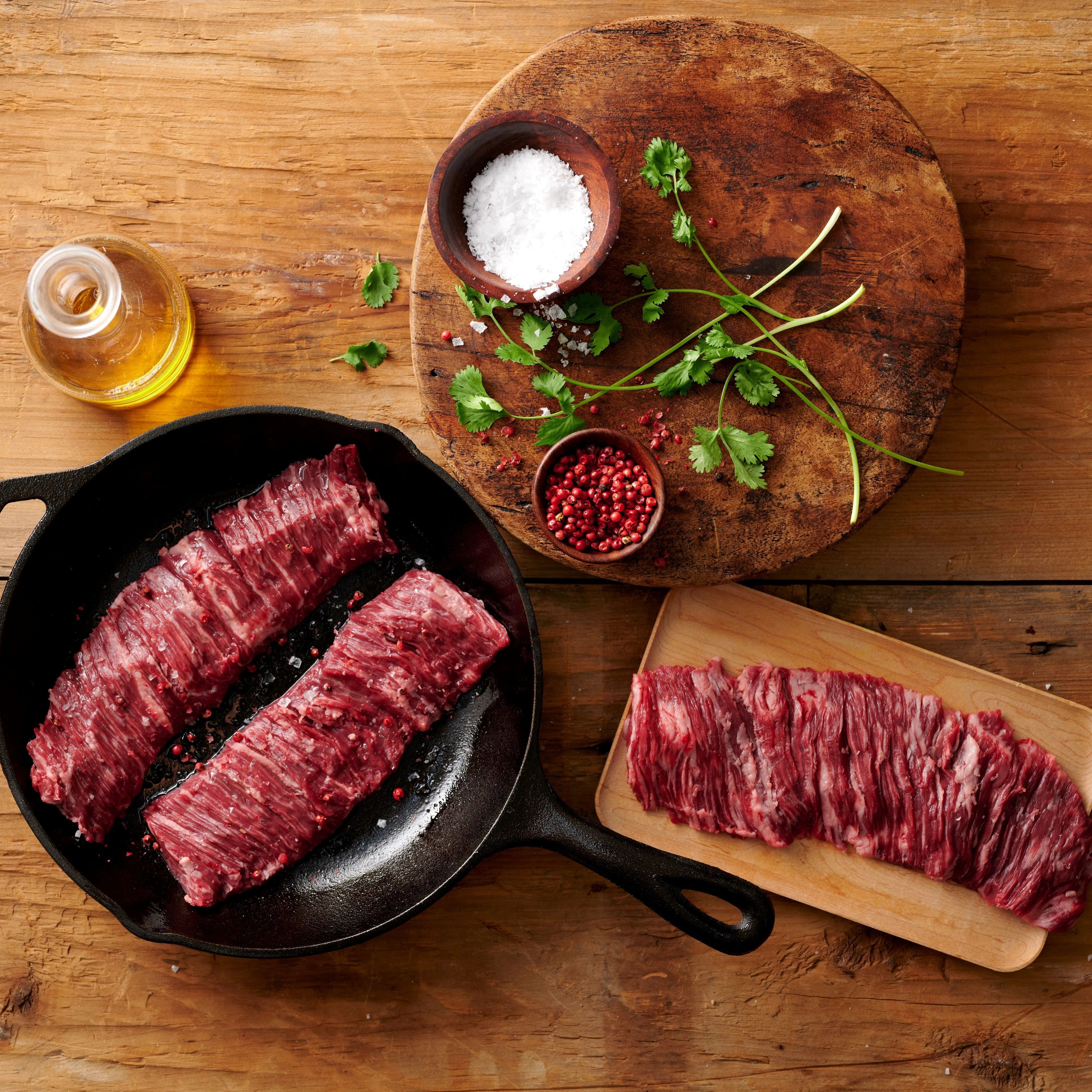 skirt and flank steaks on a skillet and cutting board with seasoning display